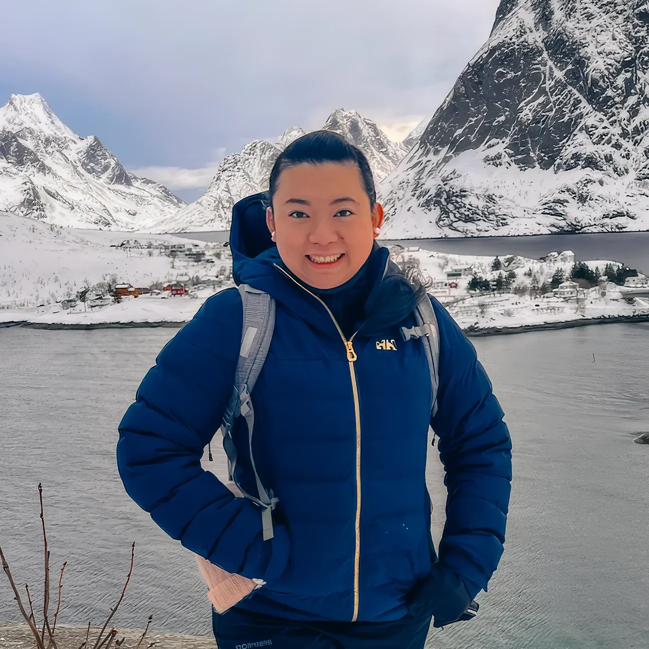 Profile image of Northern Lights tour guide Zeline outdoors near a fjord surrounded by snow-covered mountains.